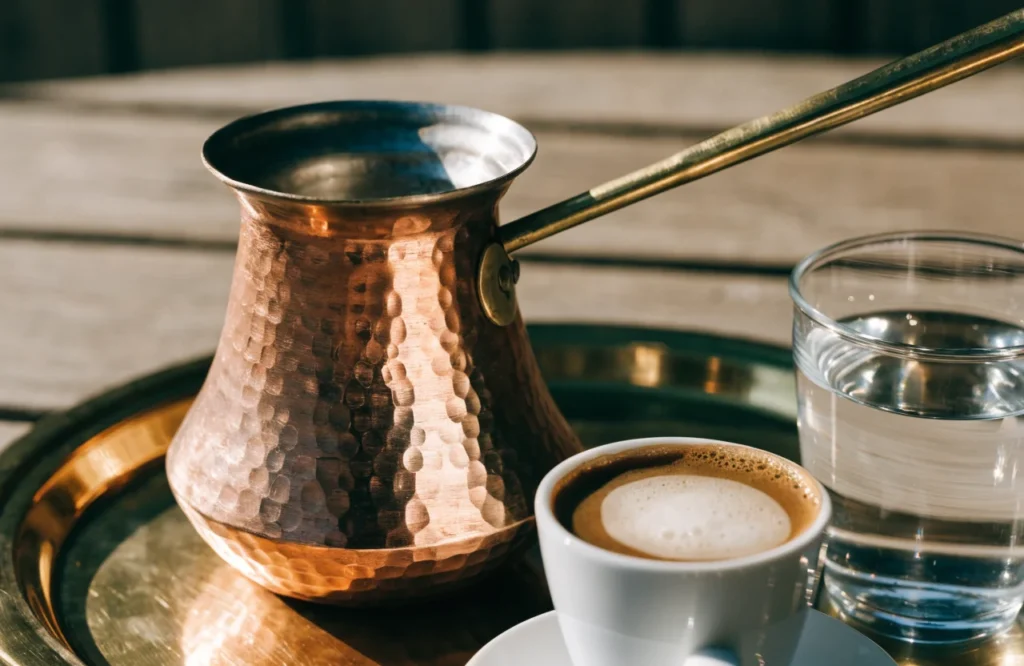 Hand-hammered copper cezve with a cup of Turkish coffee