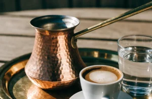 Hand-hammered copper cezve with a cup of Turkish coffee